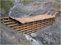 Fig. 25 - Barrage à doubles parois avec parement réalisé avec des bois verticaux.